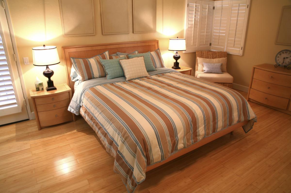Если спальня небольшая, то лучше выбирать ламинат светлых оттенков, чтобы визуально расширить комнату 